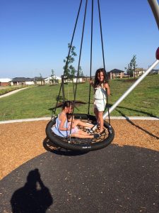 three sisters on an a_space birds nest swing seat for an inclusive playspace