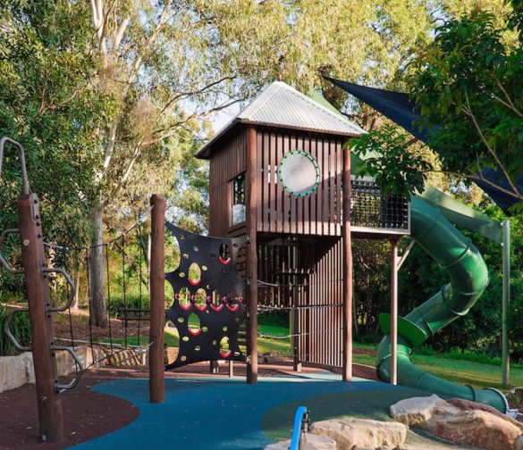 A wide-shot of a wooden playground and blue flooring