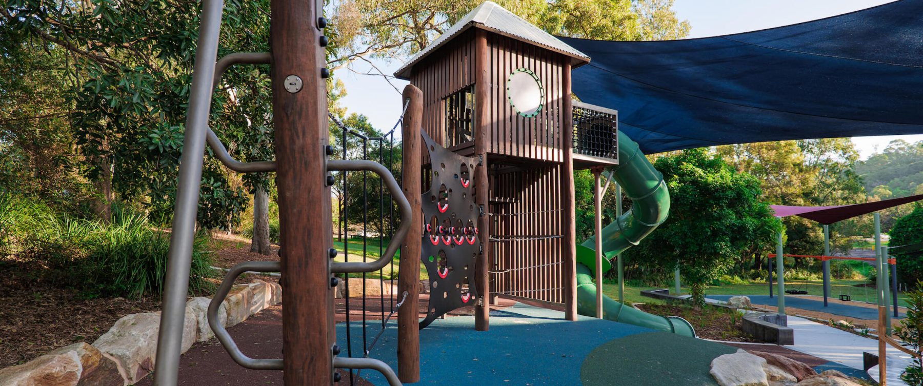 Wooden playground with a metal climbing pole
