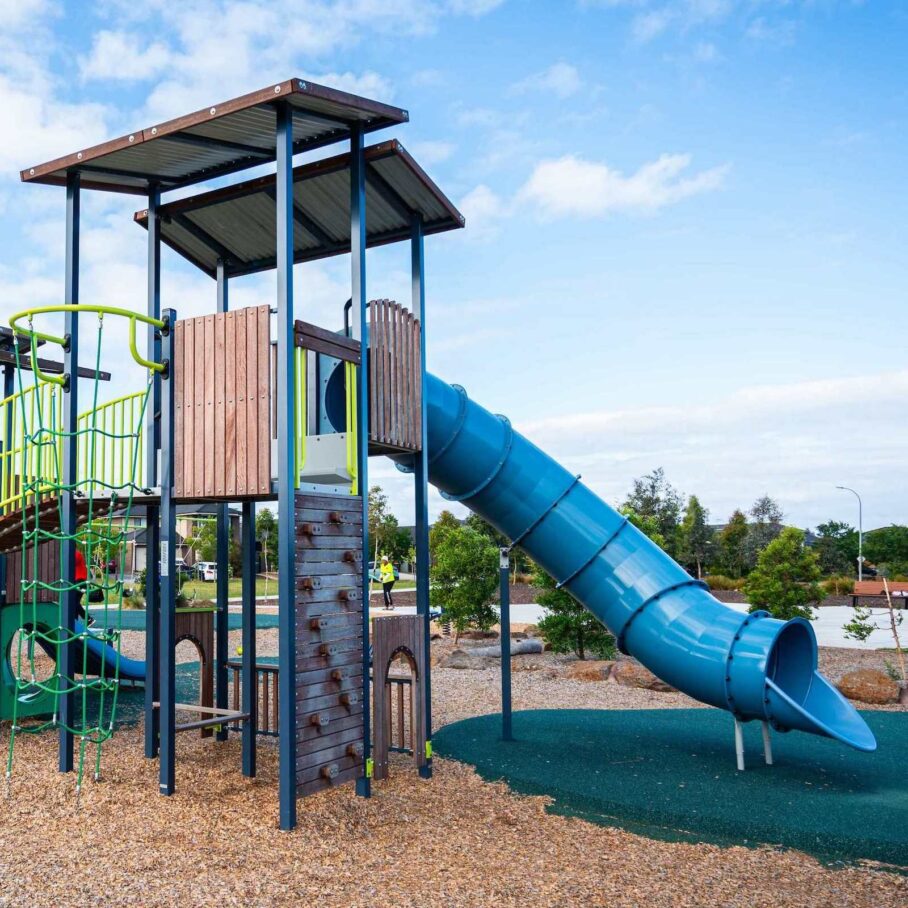 Playground with climbing wall and blue tunnel slide