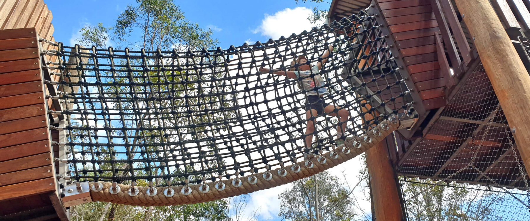 a child crossing a net bridge