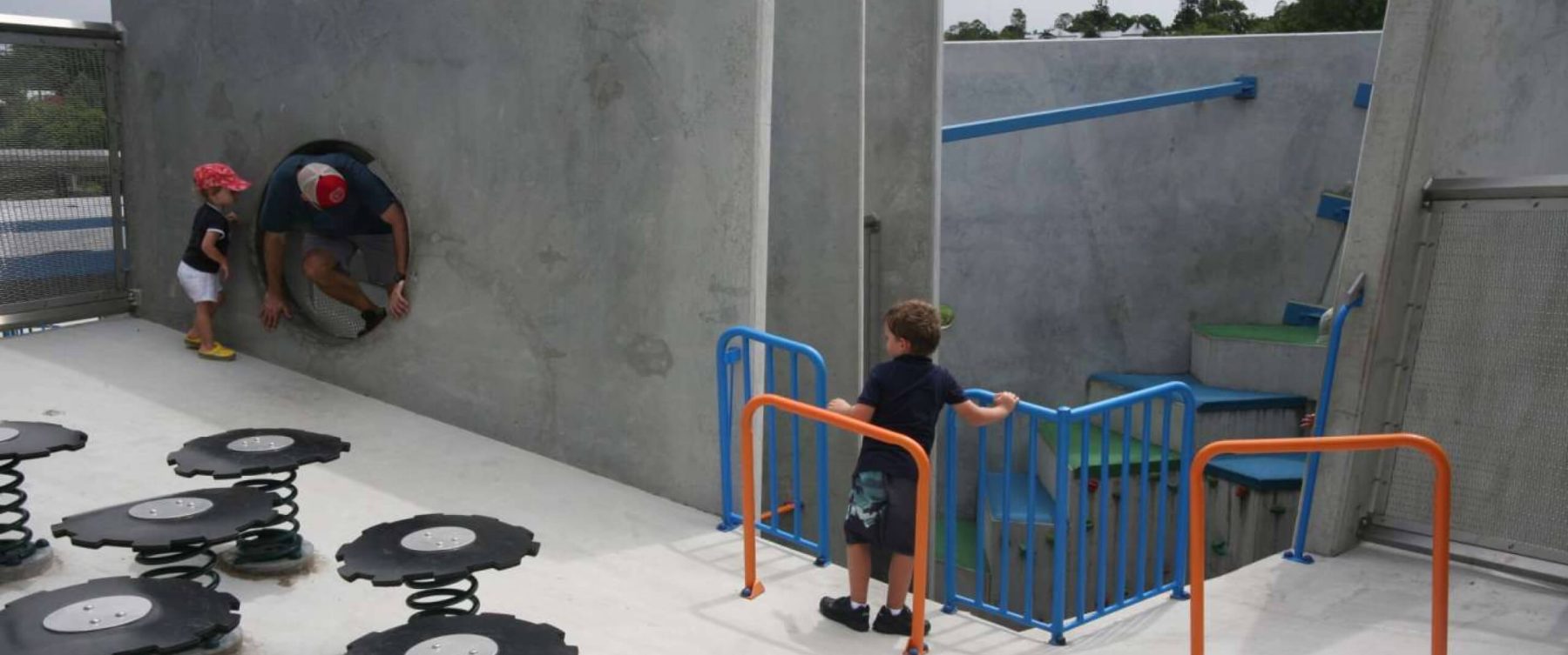 a child in rollerblades holding on to colourful railings