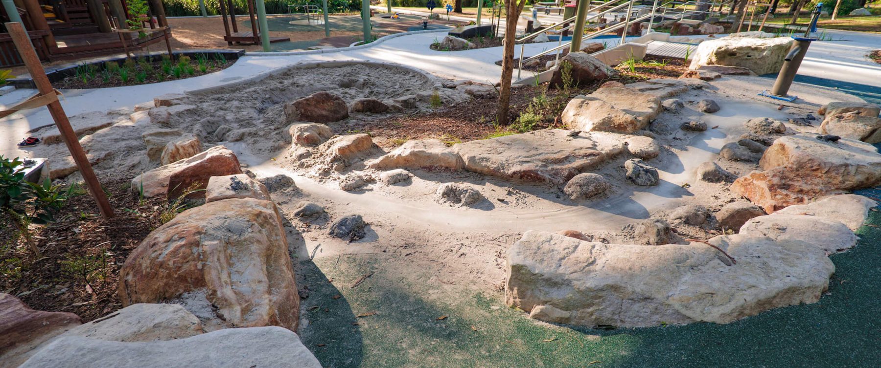 a sloped sand trail with a water pump