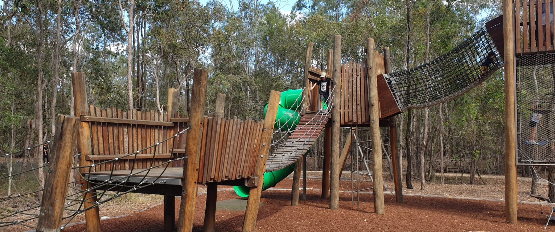 a playground with a wooden bridge
