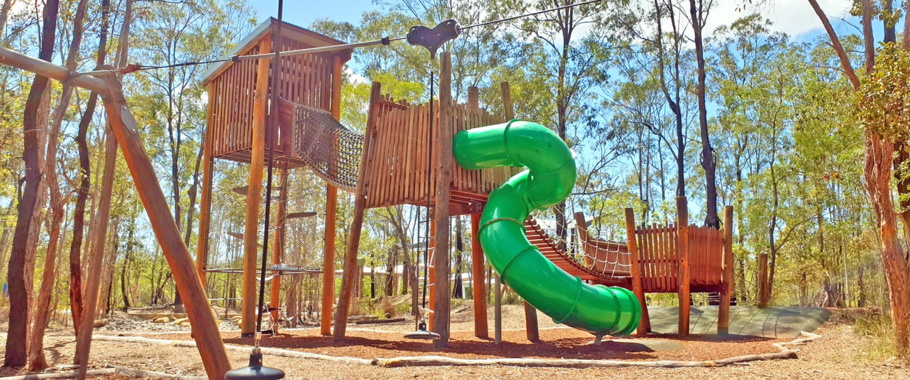 a wooden fort with a green slide